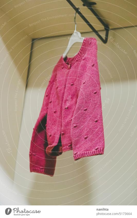 Only one vintage pink sweater in a wardrobe fashion baby clothes jacket wool wollen hand made only closet isolated retro copy space girl gender femininity