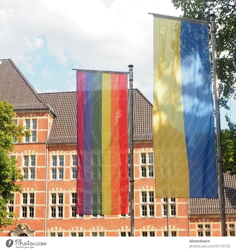 Rainbow and Ukraine flag side by side in front of old building in Hamburg vertical on flagpole Flags Hanseatic City Vertical Tall Portrait format rainbow flag