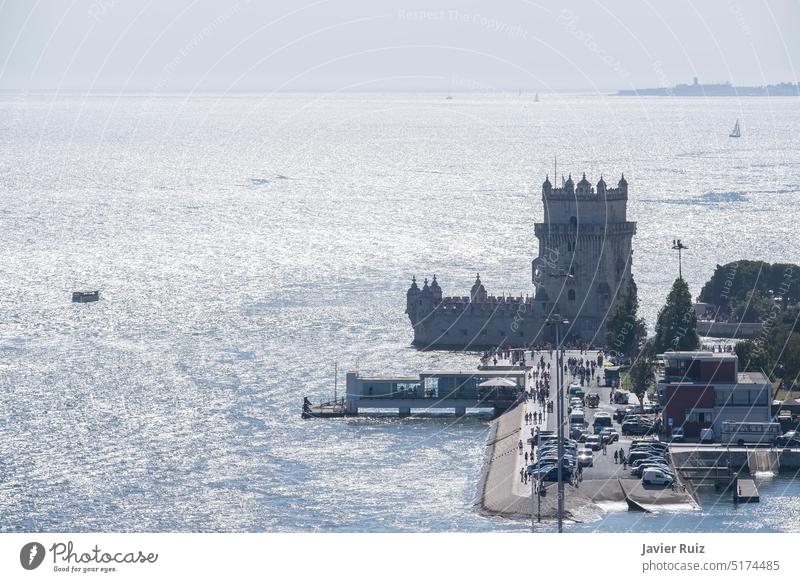 aerial image of the Tagus river estuary in Belem, Lisbon, boats on the river, distant people visiting the tower of Belem backlight lisbon portugal tagus
