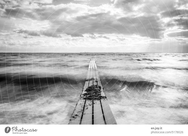 small wooden jetty on the Baltic Sea wooden walkway Ocean Footbridge Waves Long exposure Black & white photo Horizon Clouds blurriness Water Deserted Sky