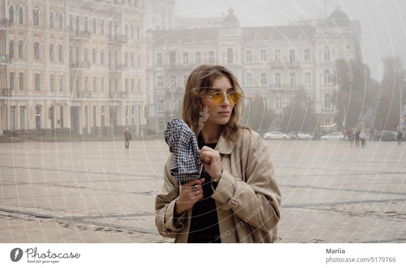 Girl in yellow glasses in the fog pretty woman Yellow Yellow glasses Fog City cityscape Umbrella young female adult portrait town square Square Architecture