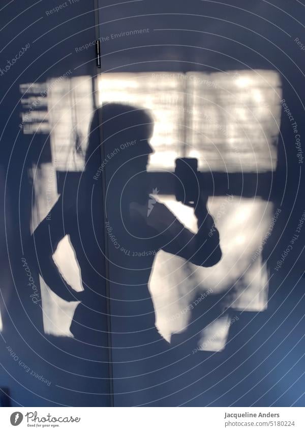 Shadow of woman taking selfie of herself with cell phone Woman Shadow play Wall (building) Cellphone Selfie Sunlight Silhouette Contrast Light Light and shadow