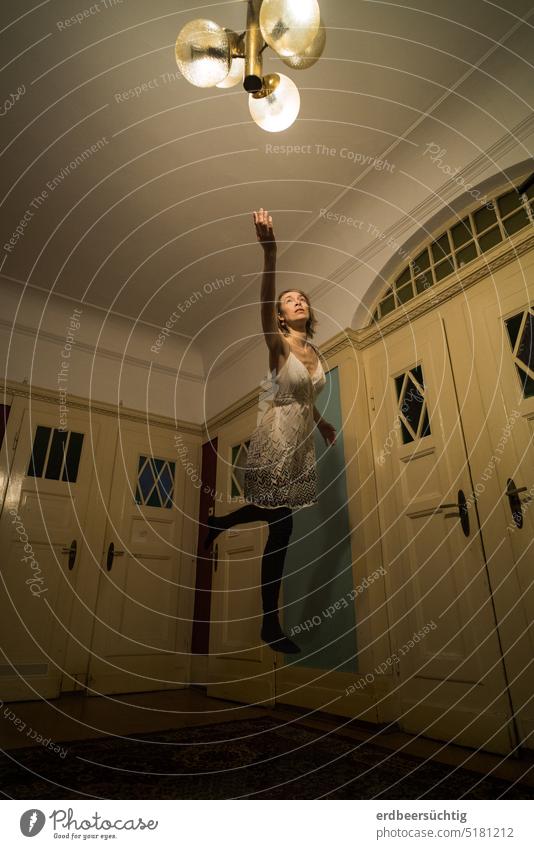 Ascender - woman floats in large hallway towards the light of the lamp Woman Flying flight flight tests Room Hallway Lamp Art deco Old building Hover dim Go up