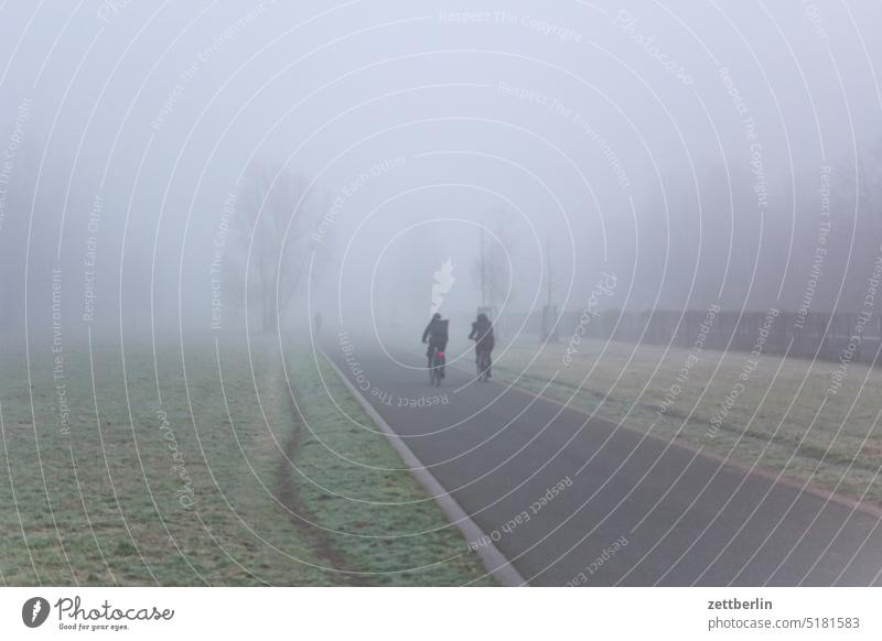 Bike path in fog hazy Haze Cycle path Autumn Morning Fog foggy cycle path Weather Winter cyclists two Couple duo at the same time Direct autumn baluschek park