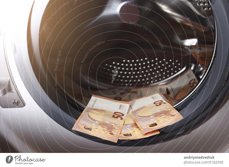 Euro money banknotes in washing machine - illegal cash 50 and mafia money laundering - tax evasion in Europe inflation and impairment. money laundering concept - euro banknotes in washing mashine