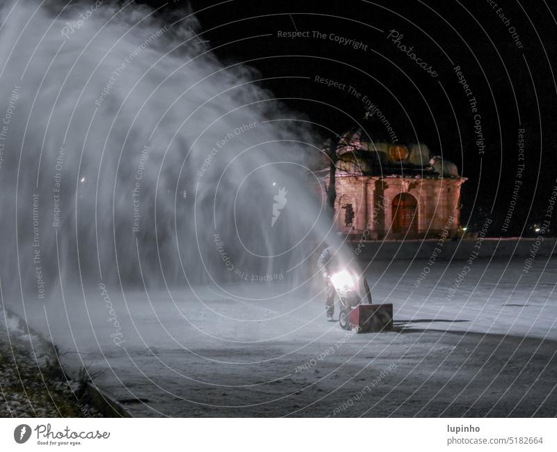 Man works on ice surface in the evening, with a snow blower Ice Frozen surface frozen canal Winter Snow snow dust Evening Channel Light Dark fountain January