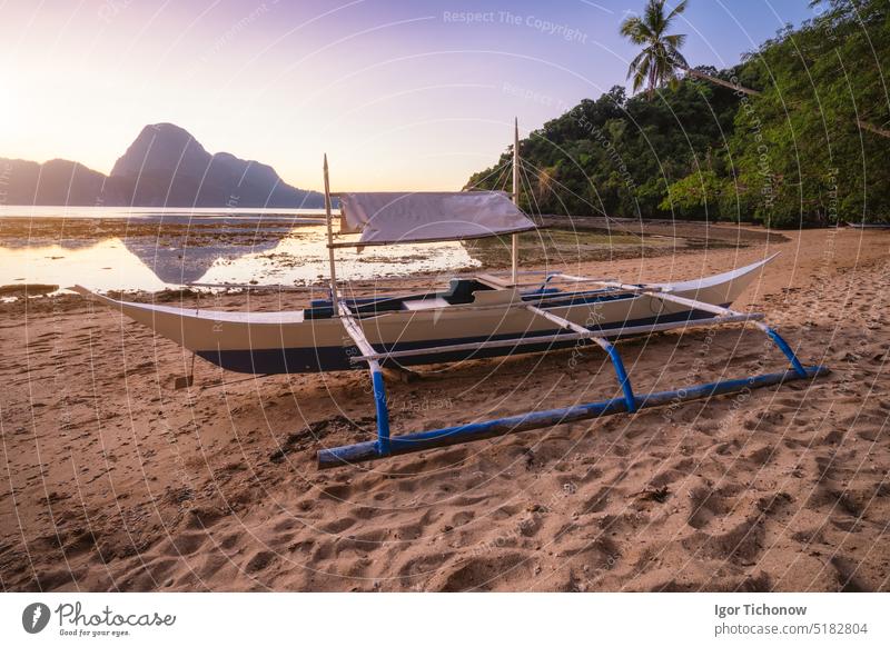 View of El Nido bay with local banca boat in front at low tide, picturesque scenery in the afternoon, Palawan, Philippines travel vacation philippines sunset