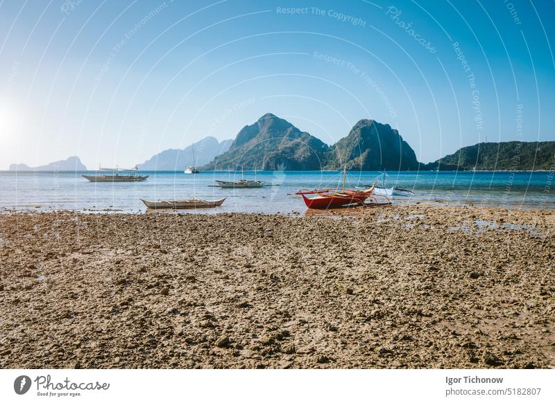 El Nido, Palawan,Philippines. Local fishing boats during low tide at Las  Cabanas Beach with amazing mountains in background - a Royalty Free Stock  Photo from Photocase