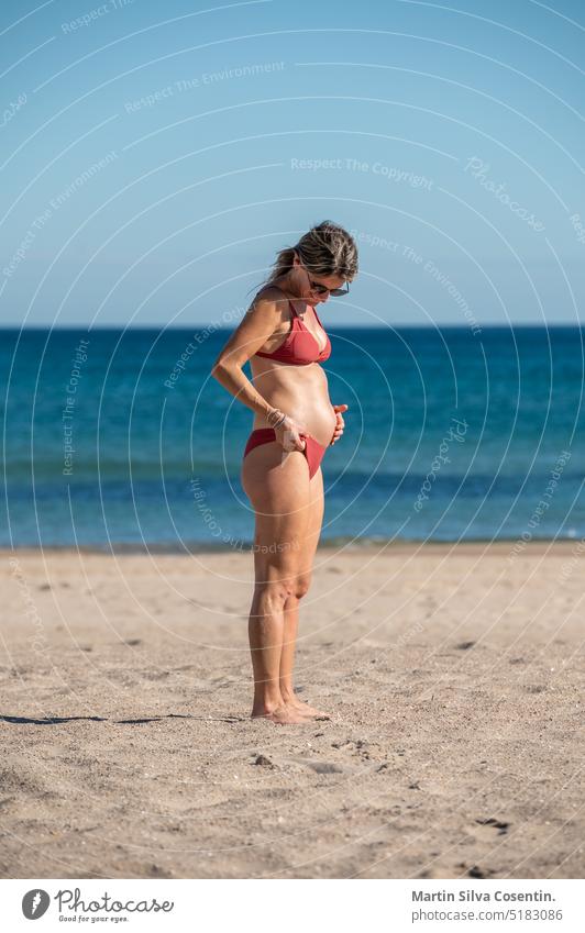 Pregnant woman on the beach of Alicante in Spain abdomen adult awaiting baby beautiful beauty belly birth care childbirth family female girl happy healthy human