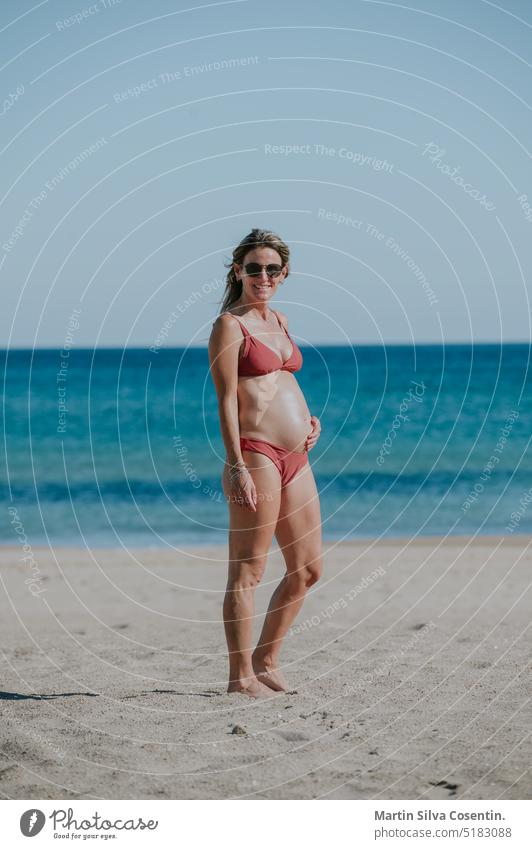 Pregnant woman on the beach of Alicante in Spain. abdomen adult awaiting baby beautiful beauty belly birth care childbirth family female girl happy healthy