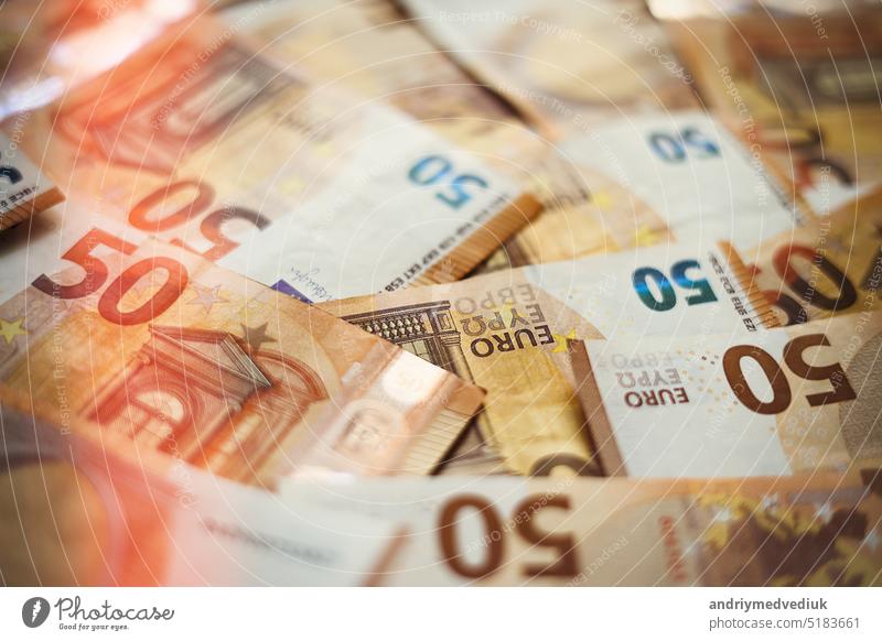50 Euro money currency banknotes background with lighting. European paper money backdrop with 50 euros bills. Financial investment, savings, income earnings concept.