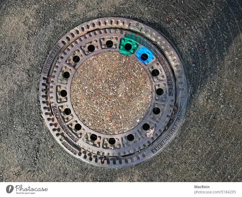 Color marked manhole cover Manhole cover Markings color marking Asphalt tar surface Street Blue Green