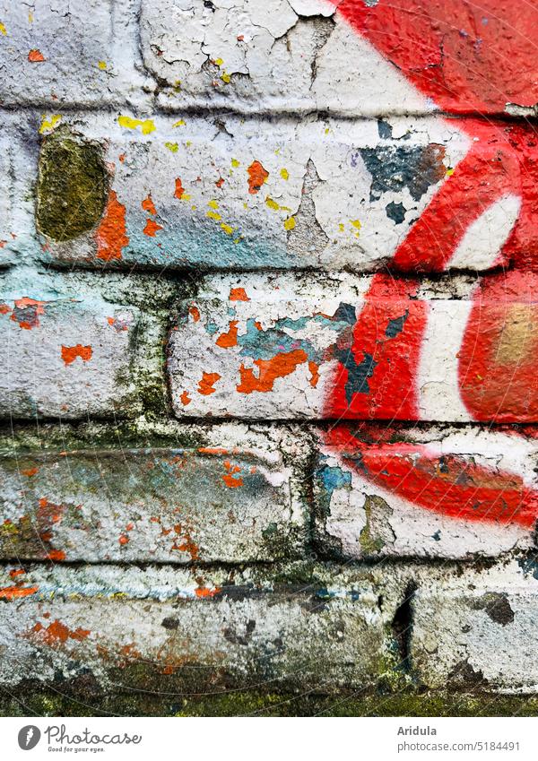 Graffiti in layers on brick wall in white and red with some light blue and yellow Wall (building) frowzy Broken Wall (barrier) Facade Old Structures and shapes