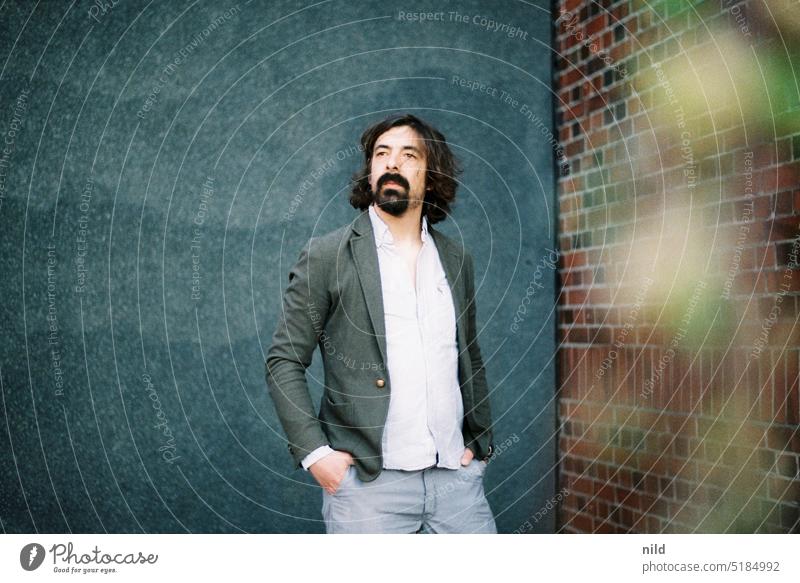 Portrait of a bearded man in front of neutral gray wall portrait Man Facial hair Masculine Meditative Looking Human being Adults Style fashion-conscious jacket