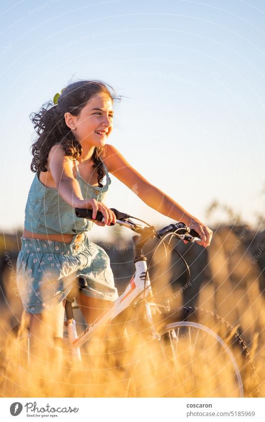 Cute girl with her bike at summer. active beauty bicycle biking blue sky caucasian child countryside cycling cyclist dry female field fit fun grass happiness