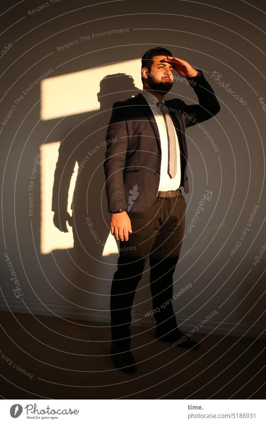 Man in suit, standing in a room looking into the evening sun portrait Optimism Self-confident Looking Beard Short-haired Black-haired Tie Shirt Masculine Jacket