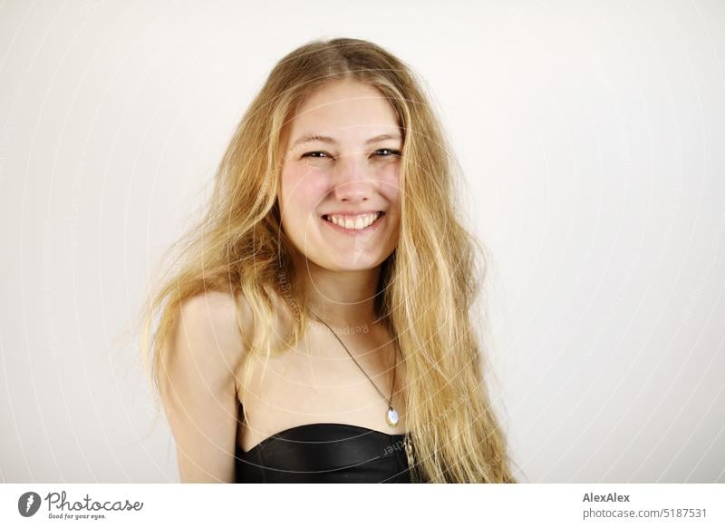 Close portrait of young blonde woman standing in front of white background Fresh Looking into the camera Expectation inside Self-confident feminine Charming