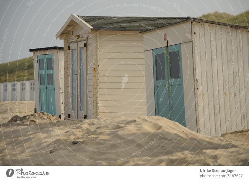 crooked beach huts blown by sand slanting Sand blows around Blown away cream turquoise doors wooden huts Huts crooked huts Cabins on the beach Vacation & Travel