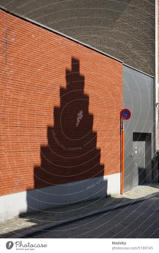 Shadow of a historic staircase gable on a facade of red-brown brick in the sunshine in the alleys of the old town of Bruges in West Flanders in Belgium