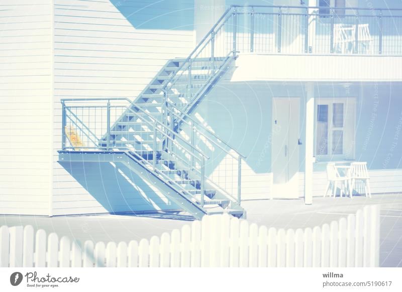 white wooden house with outside stairs Stairs Wooden house pastel Villa White Fence 50's style House (Residential Structure) unostentatious sunny Deserted