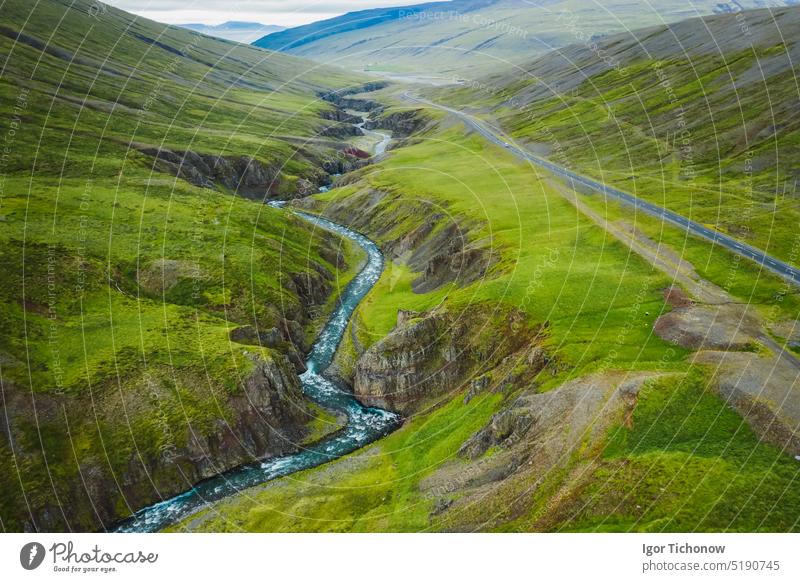 Aerial view of remote mountain road and river in the valley at north in Iceland, summertime iceland aerial green landscape nature outdoor sky travel europe