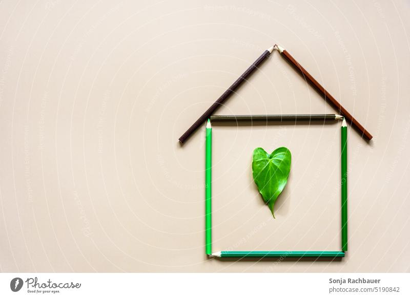 A house made of crayons with a green leaf in the shape of a heart House (Residential Structure) Creativity house purchase Symbols and metaphors Leaf Green