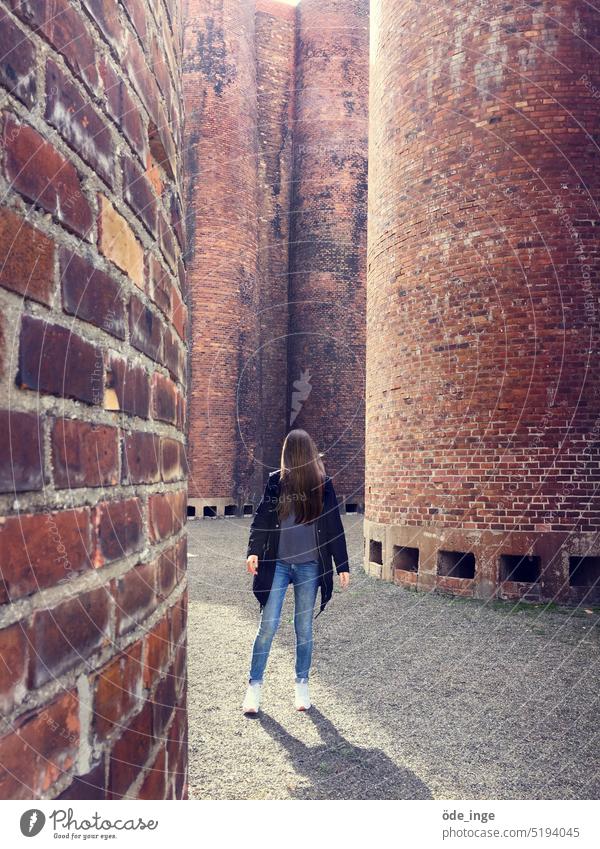camera shy Brick Woman Hair on the face spires Brick facade Brick wall Wall (barrier) Wall (building) Facade Structures and shapes Architecture Building