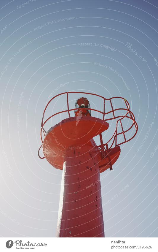 Red modern lighthouse with no people against sky red background vertical coast perspective low view architecture industry naval resource security sunny summer