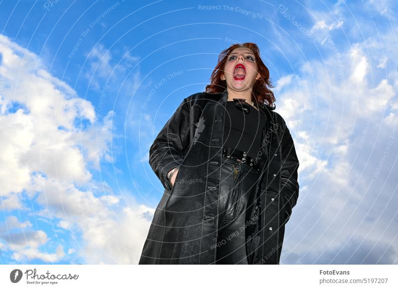 Young girl with open mouth stands against blue sky view fun scream joy nature fashion young real person screaming fashionable funny coat test space outside