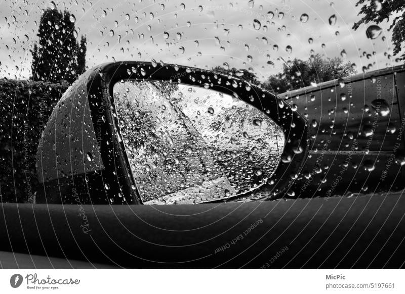 View in the side mirror on the car in rainy weather Raindrops on car window wet disc Wet Drop Safety Drops of water Bad weather Close-up Nature