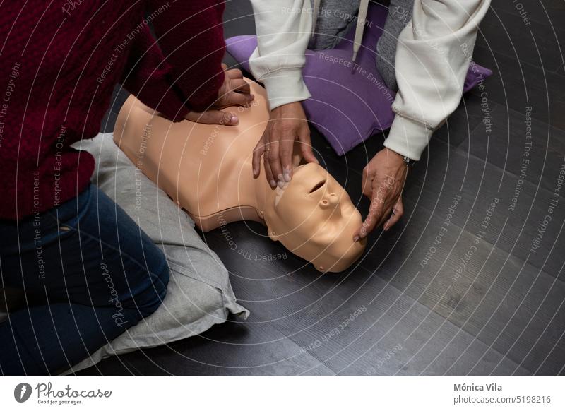 Two people practice first aid and cpr resuscitation with a cpr resuscitation manikin dummy course cpr dummy medical procedures medicine disease health