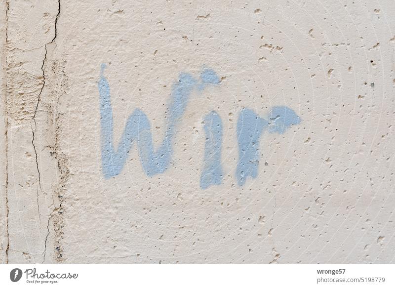 We | sprayed with light blue paint on a concrete wall Concrete wall Grafitto Colour Message embassy we Scene urban writing light blue color Town Friendship Love