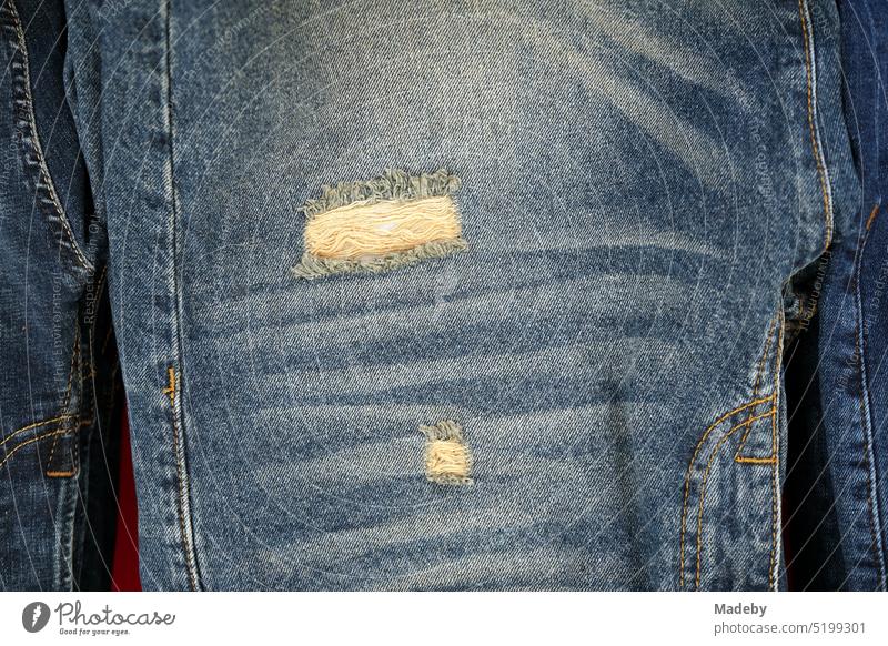 Fashionable jeans with rips or destroyed denim jeans at the weekly market and bazaar in the summer in the district of Erenköy in Sahrayicedit in Istanbul on the Bosphorus in Turkey