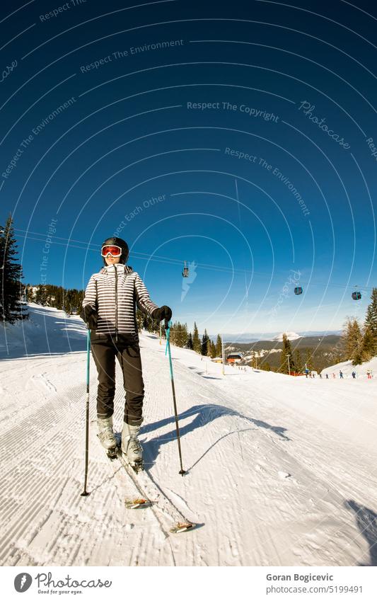 Young woman at winter skiing bliss, a sunny day adventure adult clothing cold temperature footwear full length leisure activity lens flare one person shadow sky