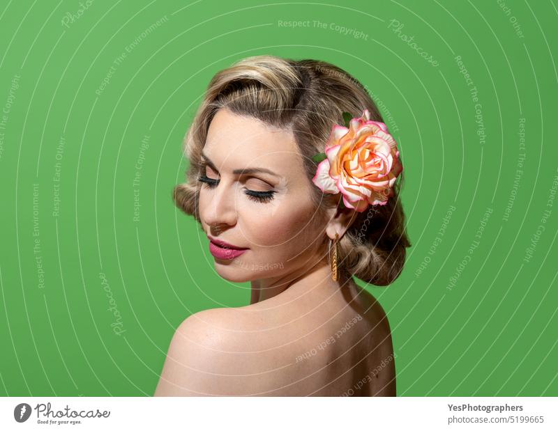 Pin up woman portrait with retro hairstyle and make up, against a green background 40s 50s accessories beauty blonde closed color concept copy space curly cute