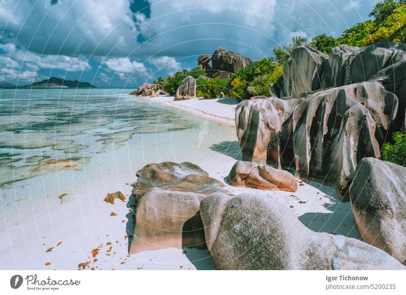 La Digue island, Seychelles. Beautiful holiday vacation view at paradise Anse Source d'Argent beach with shallow blue lagoon, granite boulders and clouds