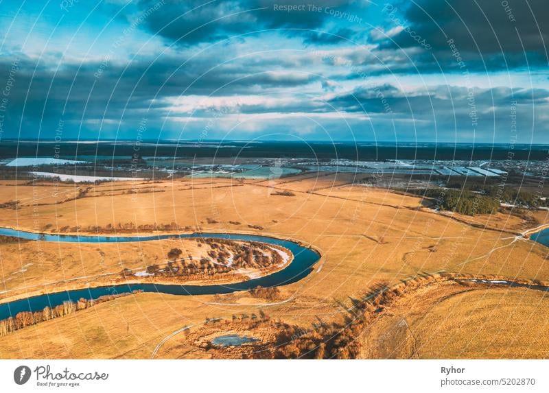 Europe. Aerial View Of Dry Grass And Partly Frozen Curved River Landscape In Autumn Day. High Attitude View. Marsh Bog. Drone View. Bird's Eye View vivid river