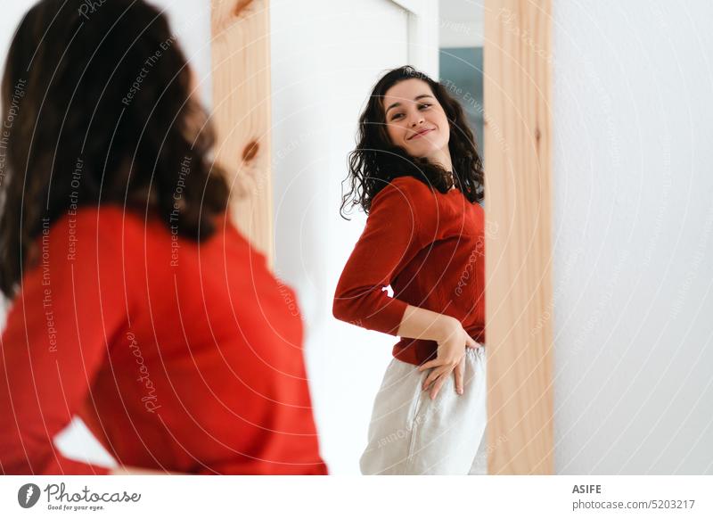 She loves herself and feels self confident young woman beautiful mirror looking happy smiling positive admiration clothing reflection choice room fashion