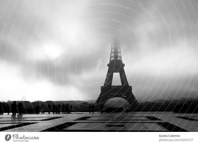 Black and white image of the Eiffel Tower in Paris, France, on a cloudy morning. paris eiffel tower paris cityscape paris france french famous monument historic
