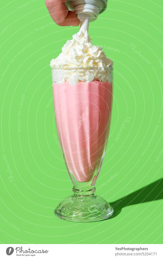 Strawberry milkshake topped with whipped cream, minimalist on a green background beverage bright can cocktail cold color copy space cuisine cup cut out dairy