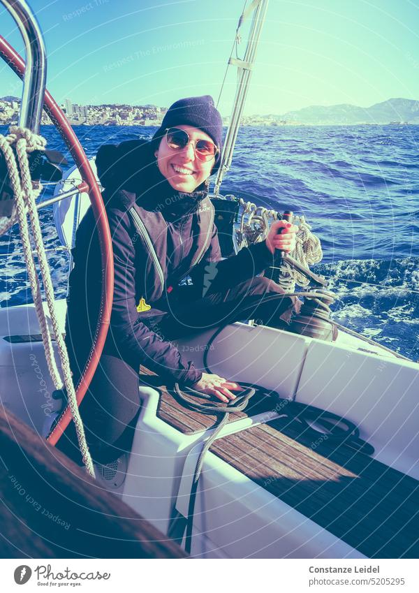 Laughing young woman with sunglasses and cap sailing. Woman Sailing Sailboat Ocean Waves Water Vacation & Travel Horizon Sailing ship Adventure Boating trip