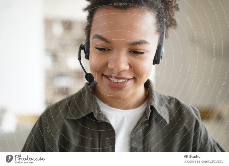 Modern mixed race teen girl student wearing headset learning online. Distance education, e-learning elearning lesson video call remote headshot listen distance