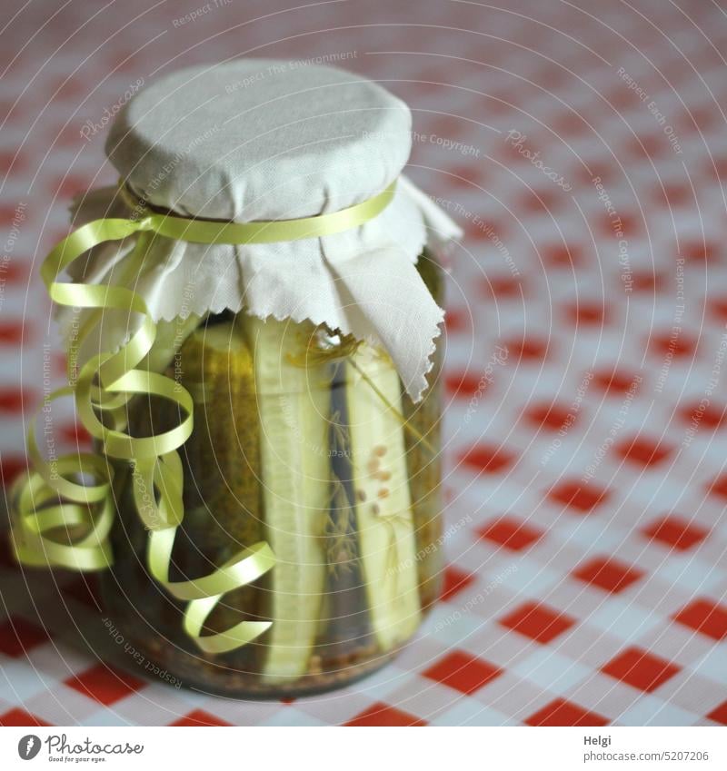 Home-cooked gherkins in a jar, decorated as a gift on a red and white tablecloth Cucumbers Gherkins Glass boiled down Gift Decoration Delicious Nutrition