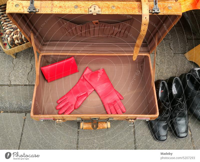 Old brown suitcase with red gloves and black shoes in the summer at the flea market and flea market at the Oldtimertreffen Golden Oldies in Wettenberg Krofdorf-Gleiberg near Giessen in Hesse