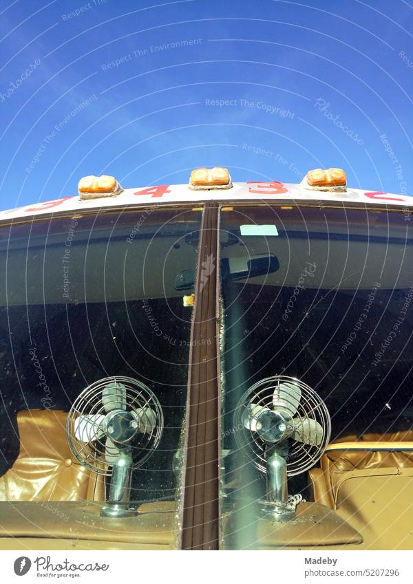 Fans on the dashboard of a classic american camper van of the luxury class in front of a blue sky at sunshine in Detmold in East Westphalia-Lippe, Germany.