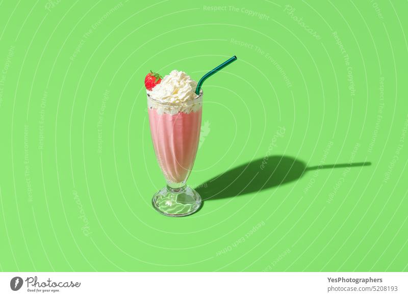 Milkshake glass minimalist on a green background. Homemade strawberries milkshake above beverage bright cocktail cold color copy space cream cuisine cup cut out