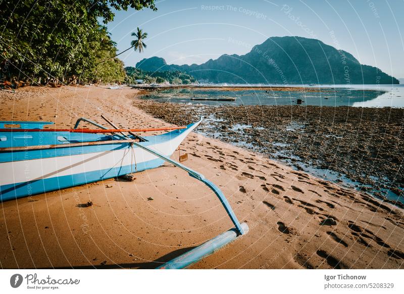 View of El Nido bay with local banca boat in front at low tide, picturesque scenery in the afternoon, Palawan, Philippines el nido shallow island hopping