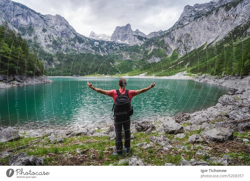 Happy traveler standing and admiring Dachstein peak mountains on a Upper Gosau Lake. Gosau, Salzkammergut, Austria, Europe gosau europe man austria dachstein