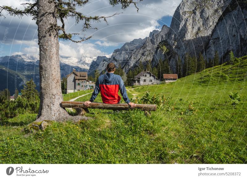 Man traveler resting on hiking trail in Gosau, Salzkammergut, Austria, Europe gosau europe man austria dachstein trunk gosausee happy peak salzkammergut scenery