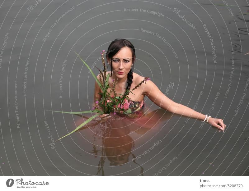 Woman with flowers in lake feminine bathe Lake Looking Relaxation portrait Upper body Dress Braids Long-haired Dark-haired look Skeptical